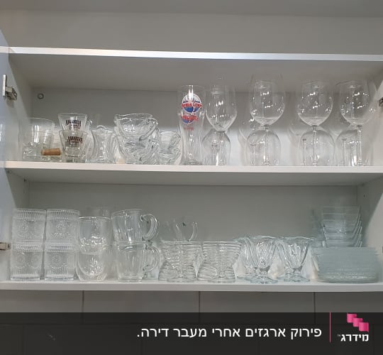 ארון מטבח פתוח עם כוסות זכוכית מסודרות